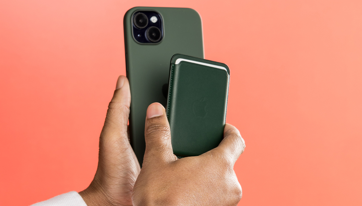 Zwei Hände mit grüner Leder-MagSafe-Kartenhalterung und iPhone.