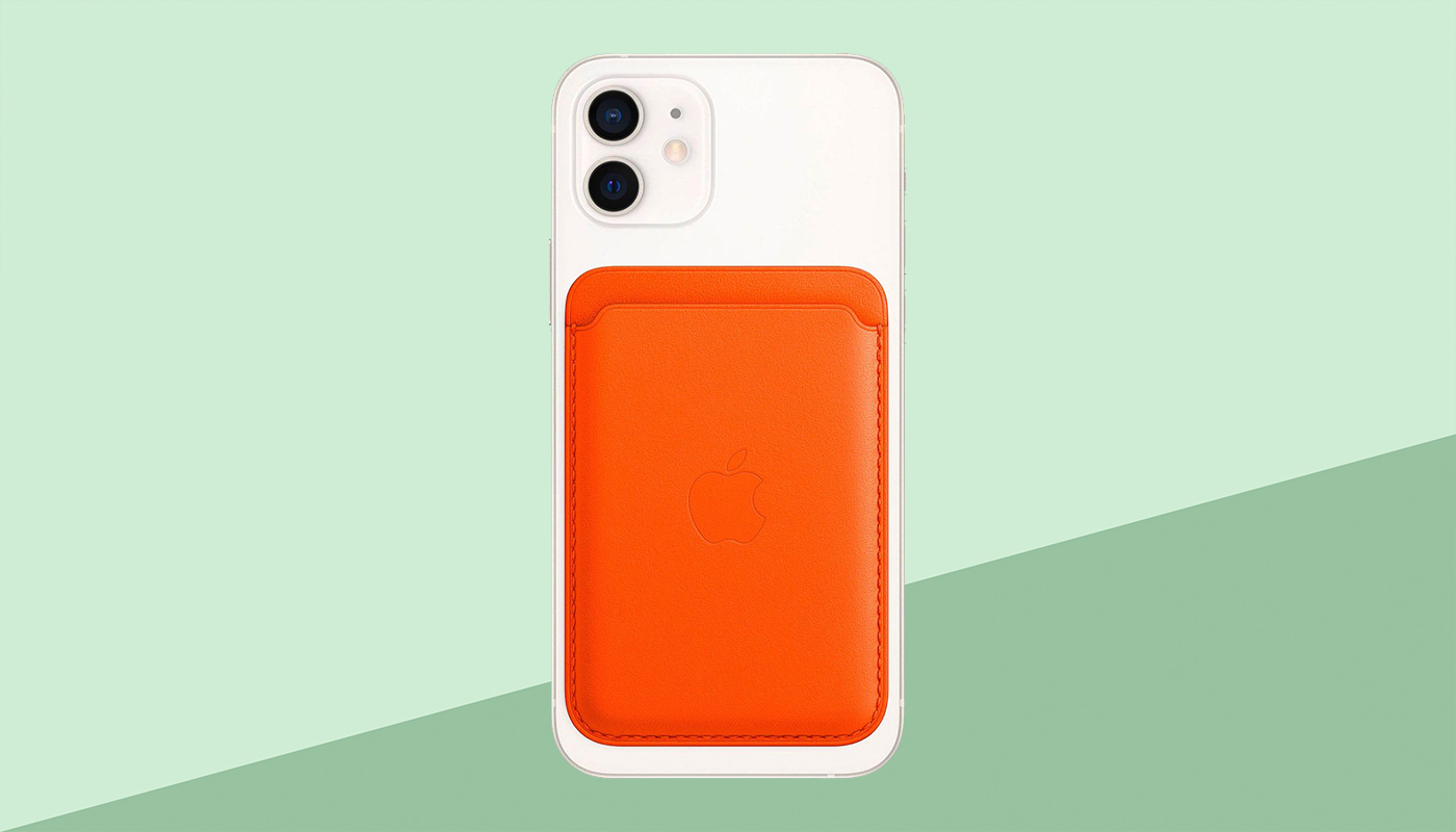 Weißes iPhone mit orangefarbener MagSafe-Ledertasche, grüner Hintergrund.