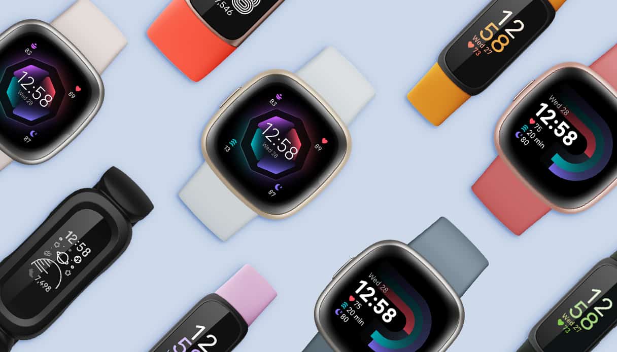 Verschiedene Fitbit Smartwatch-Modelle auf blauem Hintergrund