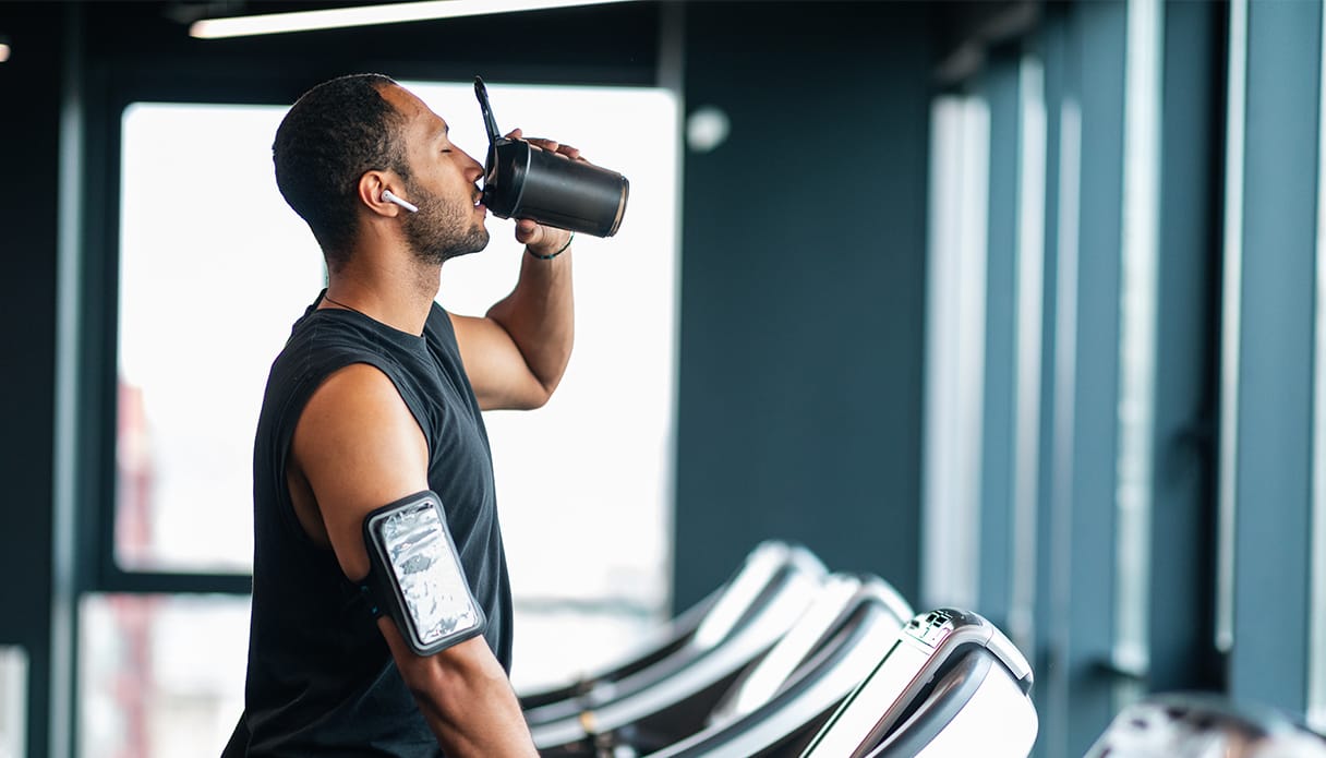 Ein Mann steht auf dem Laufband mit Apple AirPods Pro im Ohr und hört Musik.