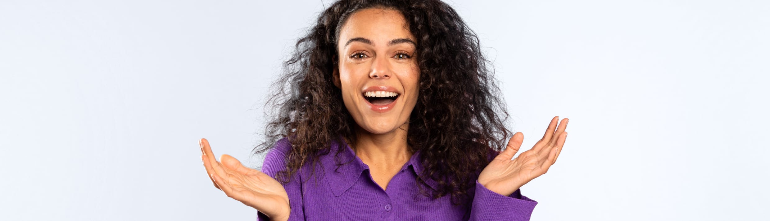 een vrouw kijkt vragend in de camera met haar handen omhoog