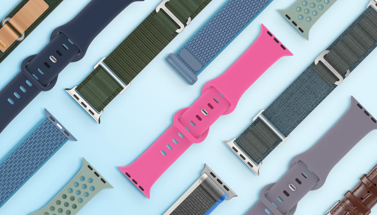 Eine Kollektion verschiedener Smartwatch-Armbänder in unterschiedlichen Materialien und Farben, ausgebreitet auf einem hellblauen Hintergrund.