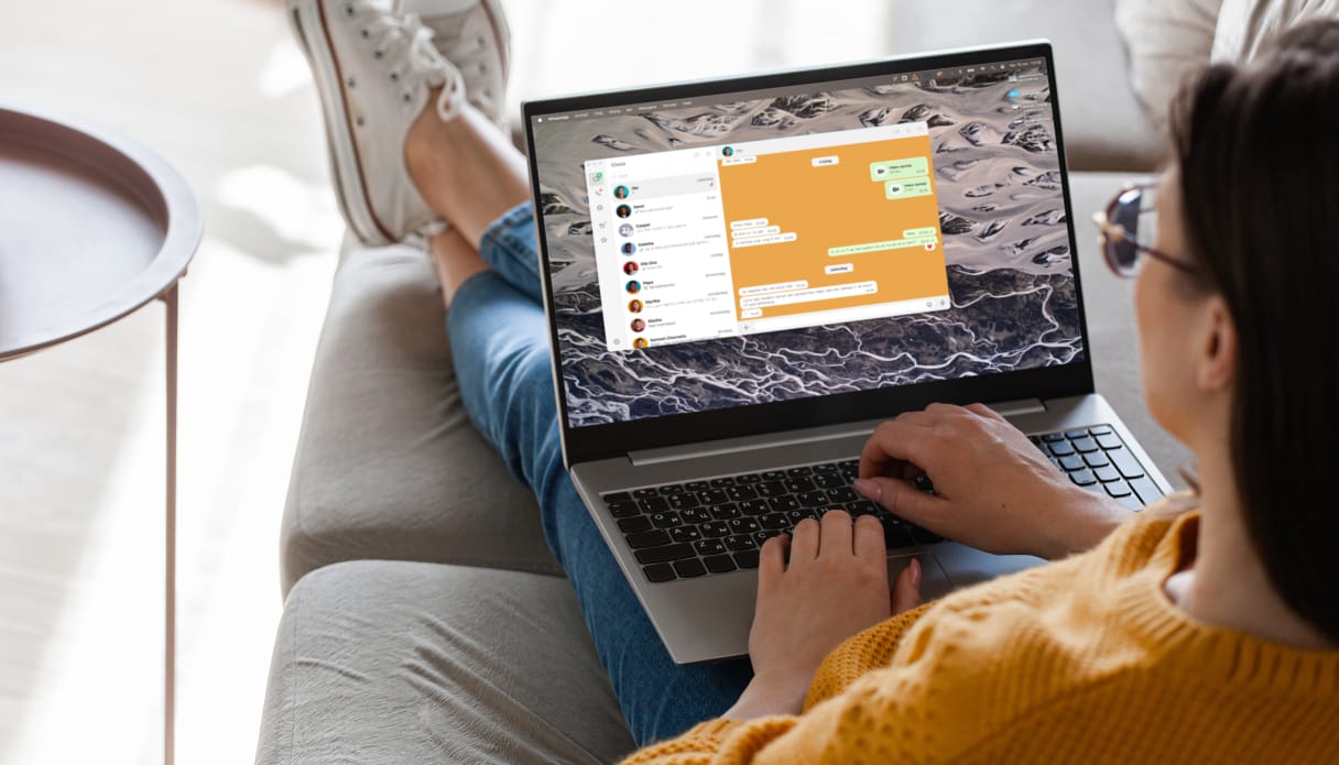 Eine Frau mit ihrem Laptop, auf dem WhatsApp geöffnet ist.