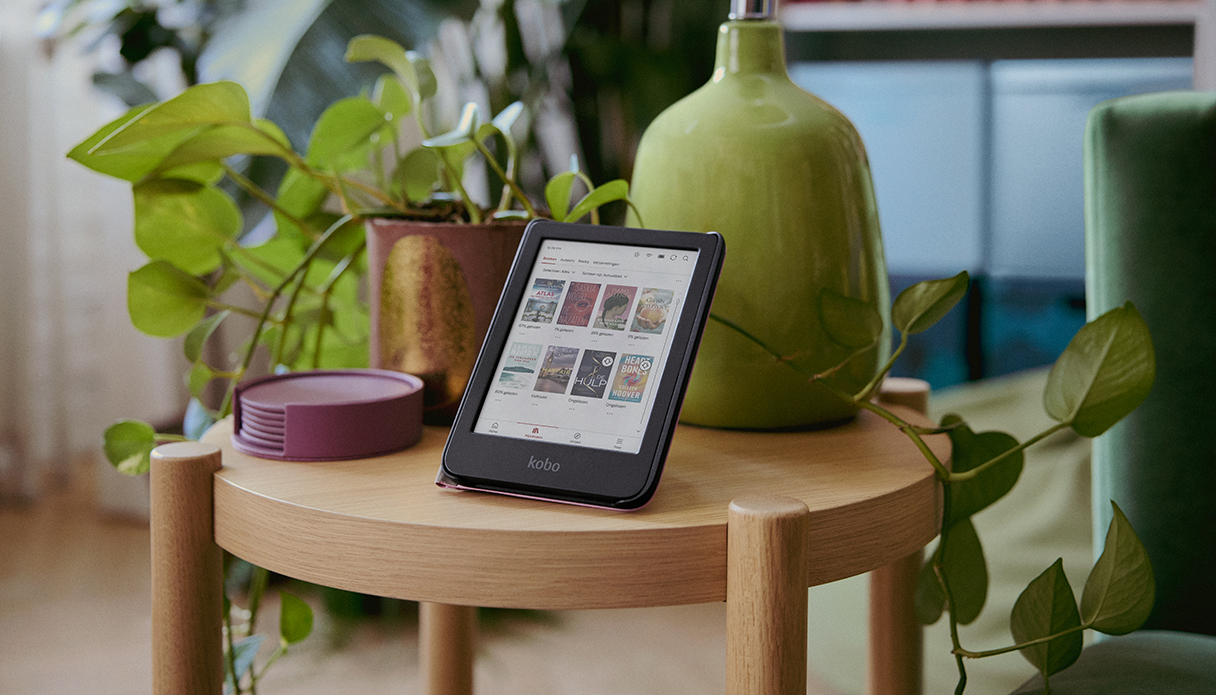 Der Kobo-E-Reader steht auf einem Tisch mit Pflanzen.