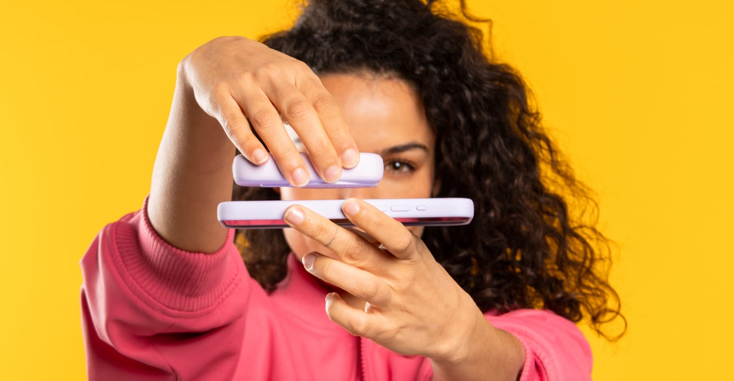 Eine Frau befestigt eine Powerbank magnetisch an ihrem Handy mit MagSafe.