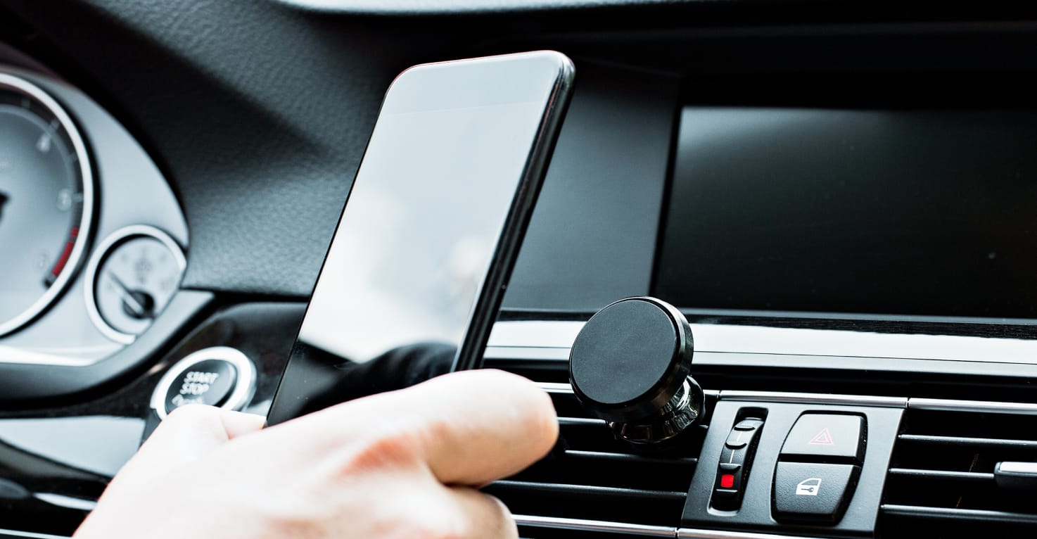 Eine Person klickt ein Telefon auf einen magnetischen Telefonhalter.