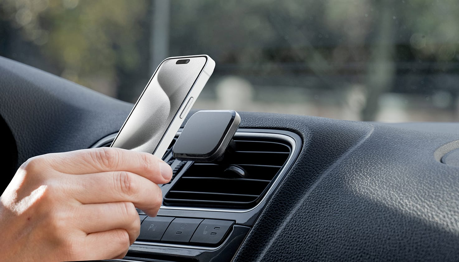 Jemand platziert ein Handy auf einem MagSafe-Handyhalter für das Auto.