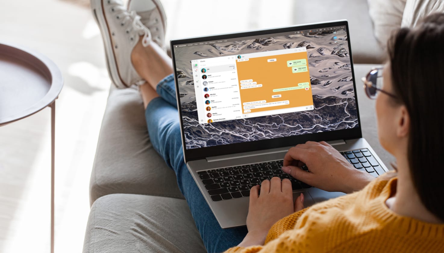 Eine Frau mit ihrem Laptop, auf dem WhatsApp geöffnet ist.