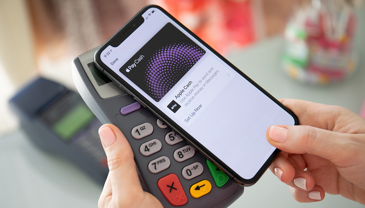 Das iPhone wird auf das Zahlungsterminal gelegt, um Apple Pay zu verwenden.