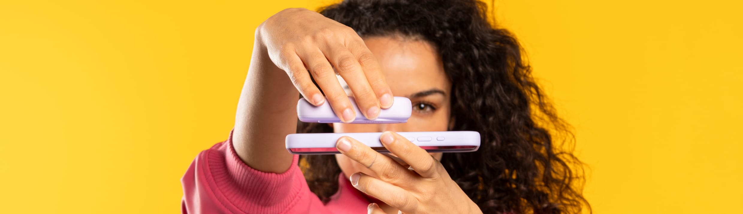 Eine Frau befestigt eine Powerbank magnetisch an ihrem Handy mit MagSafe.